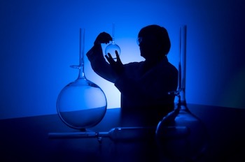 Silhouette of a female researcher carrying out research in a chemistry lab