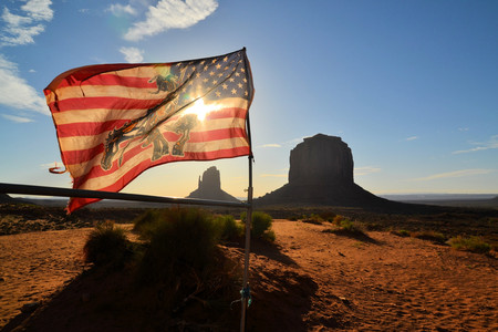U.S. Flag at Monument Valley. The valley lies within the range of the Navajo Nation Reservation and is accessible from U.S. Highway 163.