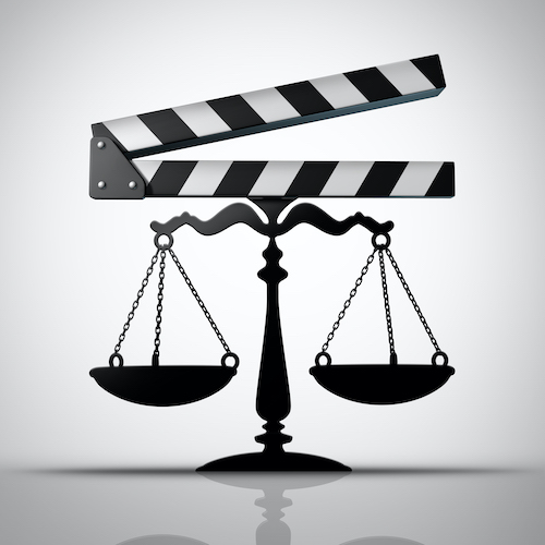 Entertainment law and media justice or TV and movie contract negotiation as a film industry slateboard or film slate shaped as a justice scale as a 3D render.